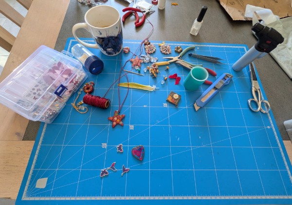 Plateau de travail en résine avec bijoux, fleurs séchées et outils de l'atelier
